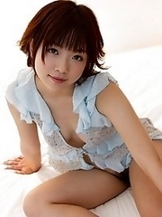 Cute and sexy Japanese av idol Mana Sakura lies on bed showing off her lovely breasts