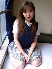 Haruka Ohsawa posing in her schoolgirl uniform and hiking up her top to show her big boobs