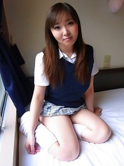 Haruka Ohsawa posing in her schoolgirl uniform and hiking up her top to show her big boobs